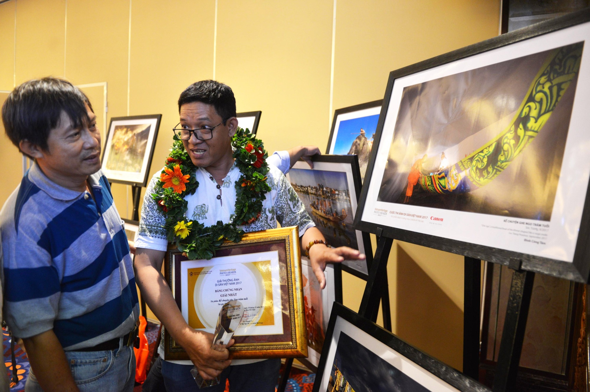 First-prize winner Dinh Cong Tam (R) explains his photo. Photo: Tuoi Tre