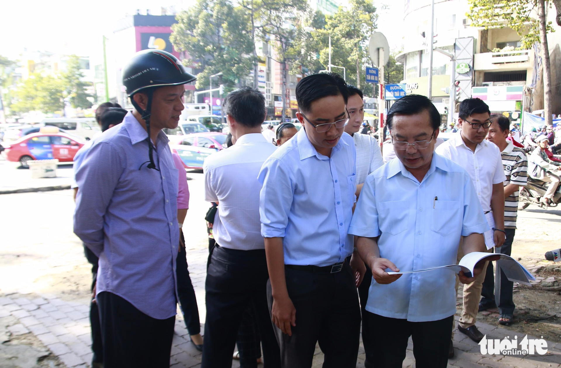 Nguyen The Thuan (R), chairman of the People’s Committee in District 1, Ho Chi Minh City, evaluates the situation on Nguyen Thai Hoc Street on November 21, 2017. Photo: Tuoi Tre