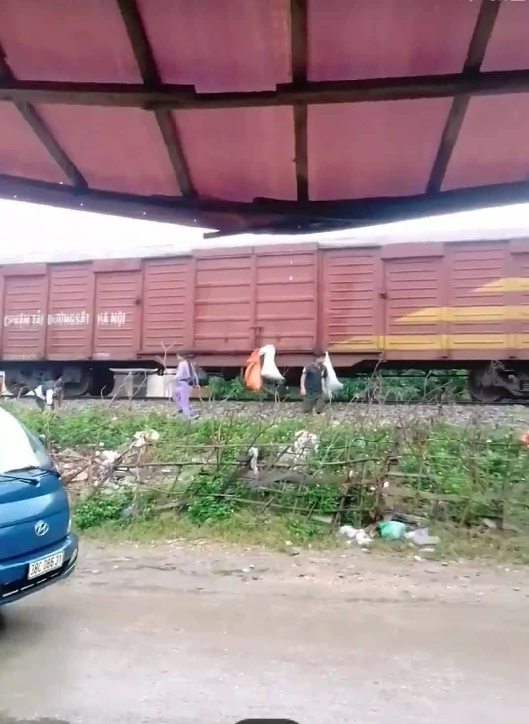 Locals hang their bags of trash on the train at Huong Pho Station.