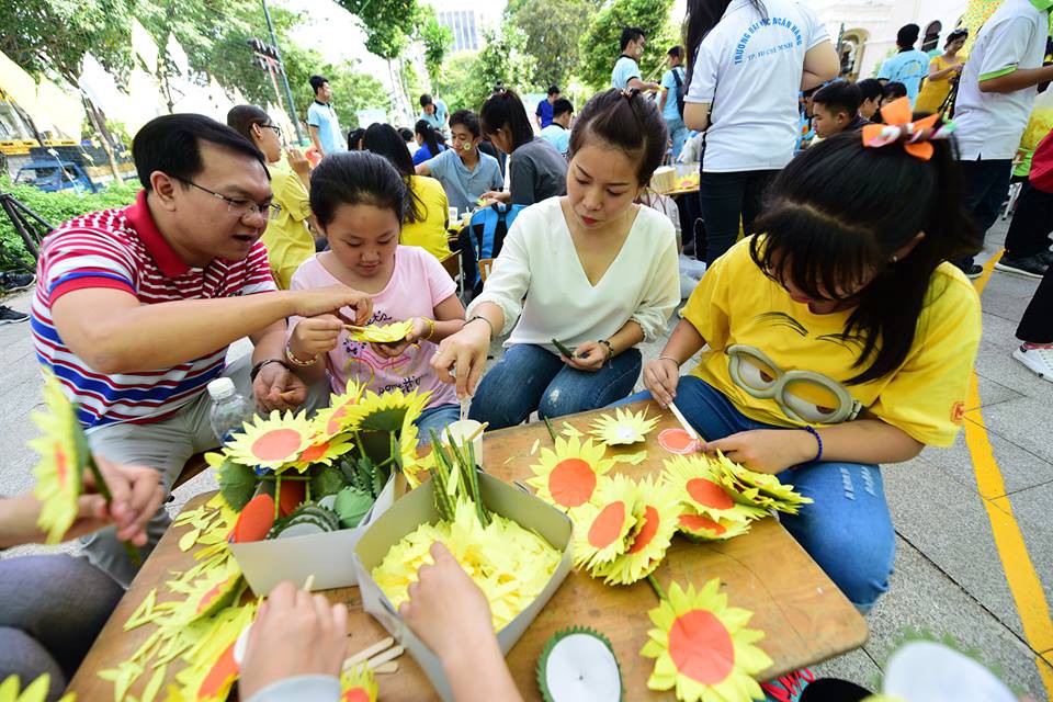 A family make paper sunflowers to help raise money.
