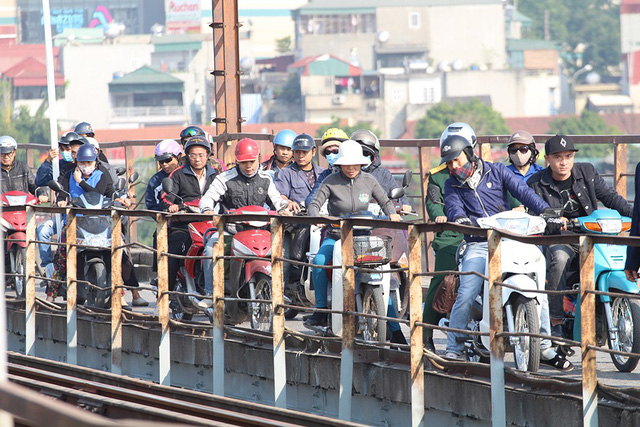 Commuters stop to watch the bomb retrieving on Long Bien Bridge.