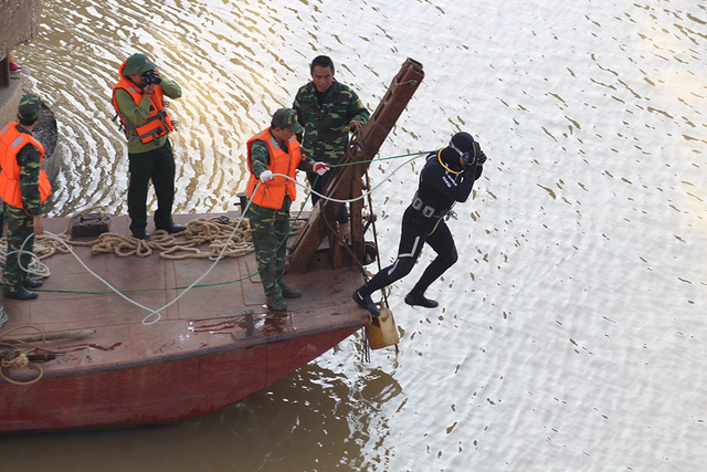 A diver jumps into the Hong (Red) River to retrieve a bomb in Hanoi, November 28, 2017. Tuoi Tre