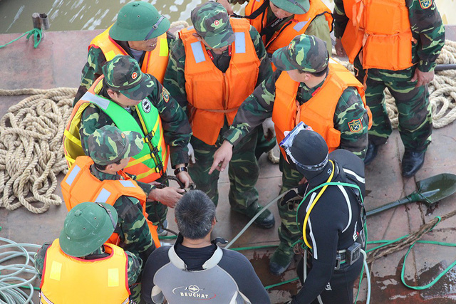 Military engineers and divers discuss before the bomb retrieving.