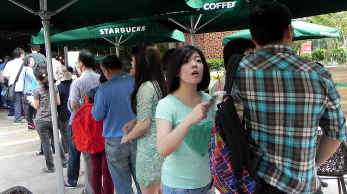 People line up outside Vietnam's first Starbucks restaurant in Ho Chi Minh City on its opening day, February 1, 2013. Photo: Tuoi Tre