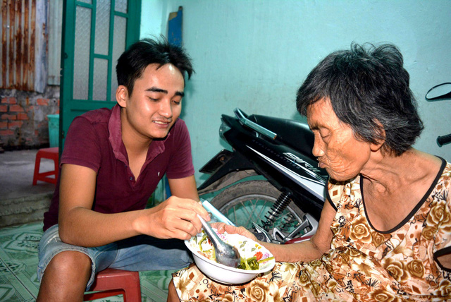 Nguyen Hong Son takes care of his 80-year-old grandmother. Photo: Tuoi Tre