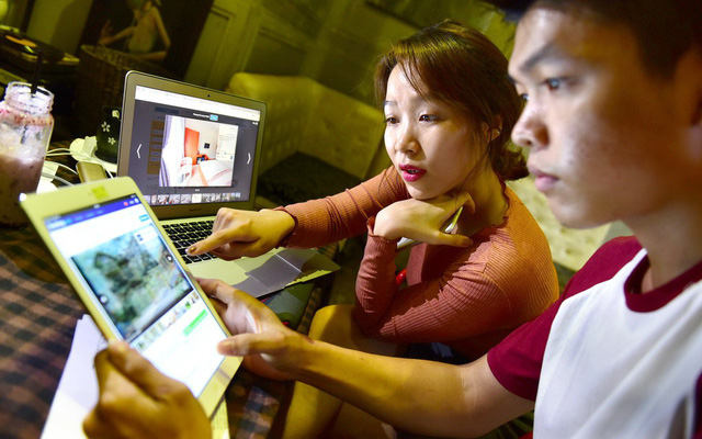 Two tourists look up information on online booking platforms prior to taking their trip to Da Nang. Photo: Tuoi Tre