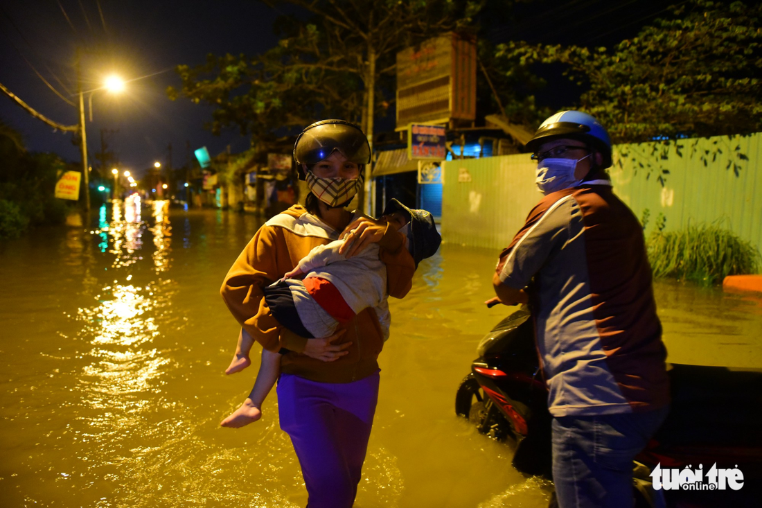 A woman holds her child amidst the floodwater.