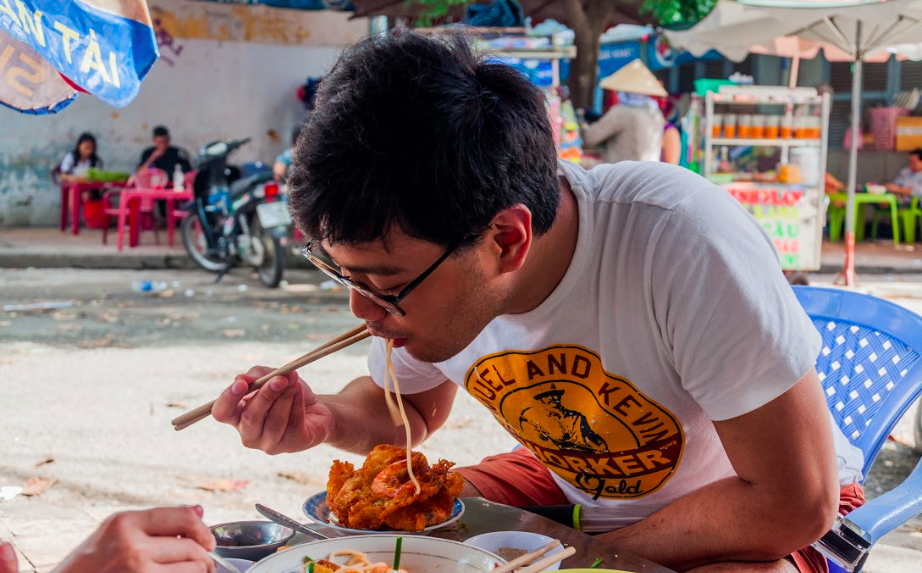 Iconic: An international visitor from the Philippines enjoys Vietnams street scene food  Photo: Vu Ha Kim Vy