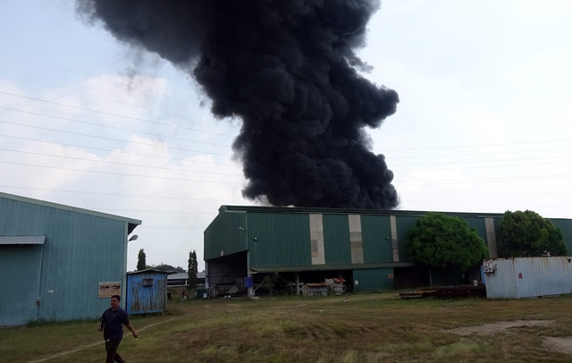 A thick column of smoke arises from the site of fire. Photo: Tuoi Tre