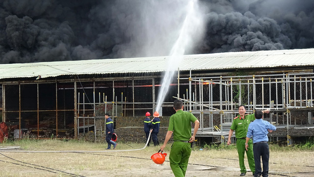 Firefighters spray water at the fire. Photo: Tuoi Tre