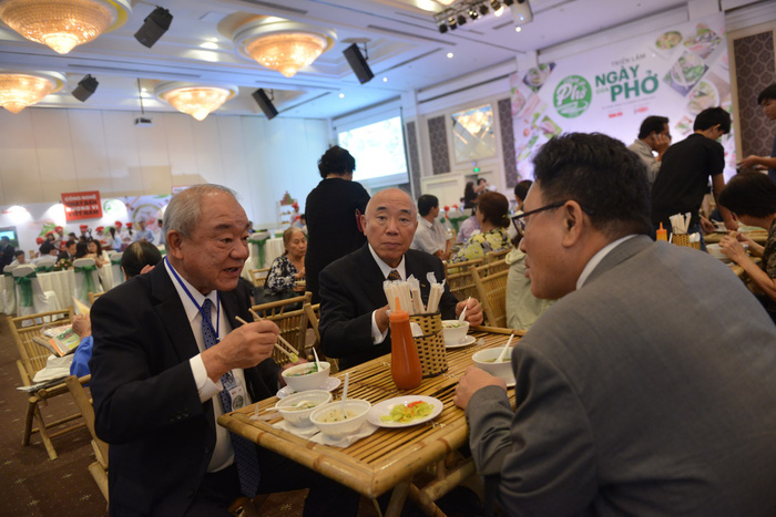 Kajiwara Junichi (L), general director of Acecook Vietnam, enjoy pho at the first Pho Day event in Ho Chi Minh City, December 12, 2017. Photo: Tuoi Tre