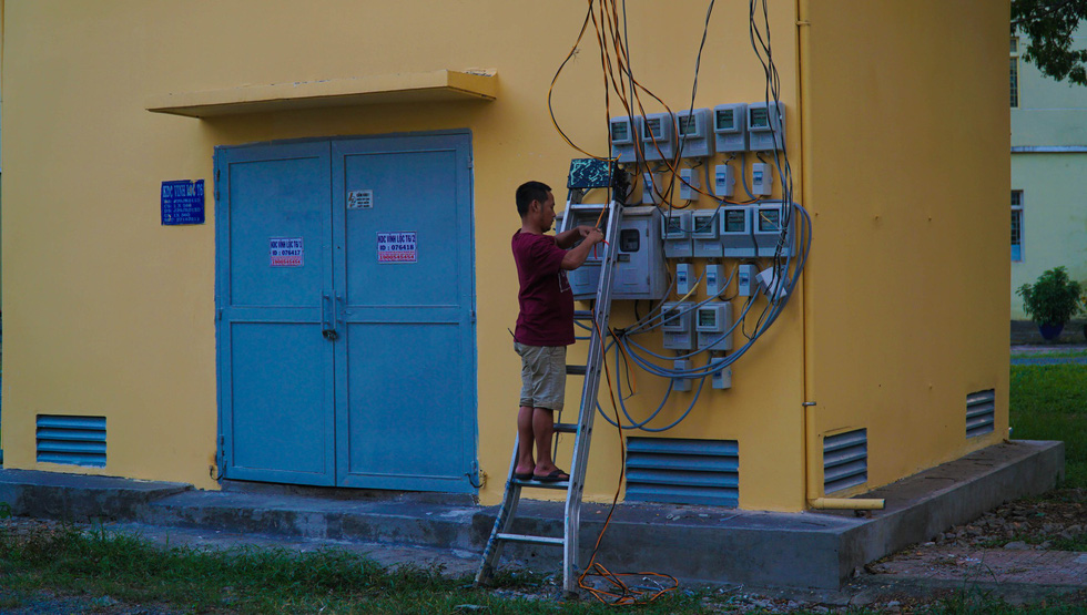 A man fixes the power lines, which often encounter problems at the relocation zone.