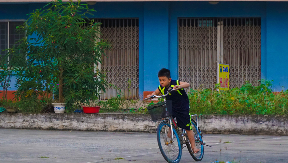 A young boy cycles alone in the complex.