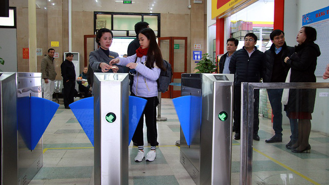 A station employee helps a passenger scan her ticket. Photo: Tuoi Tre