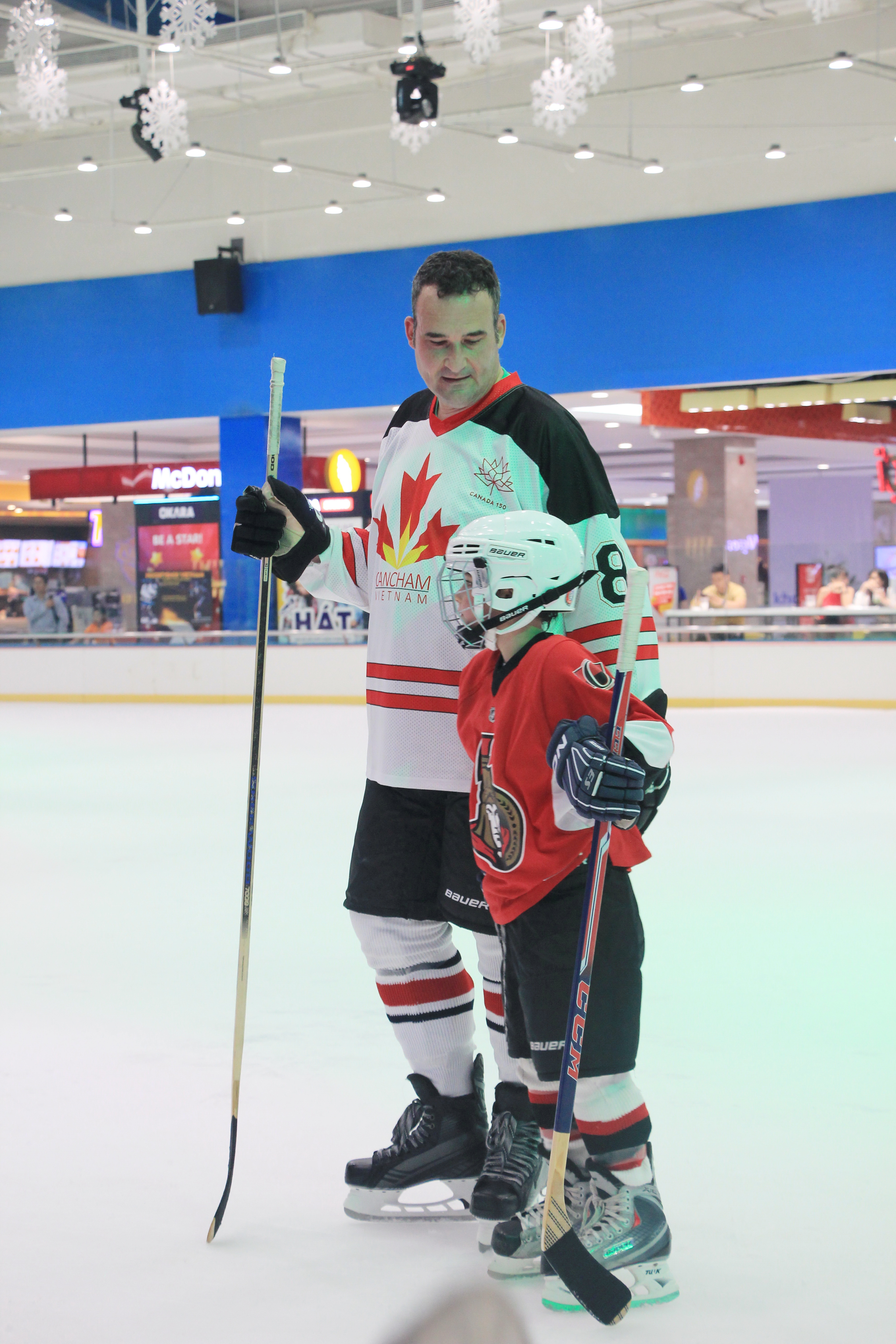 Canadian Consul General Kyle Nunas and his son in a hockey uniform at the event - Photo: Dong Nguyen/ Tuoi Tre News
