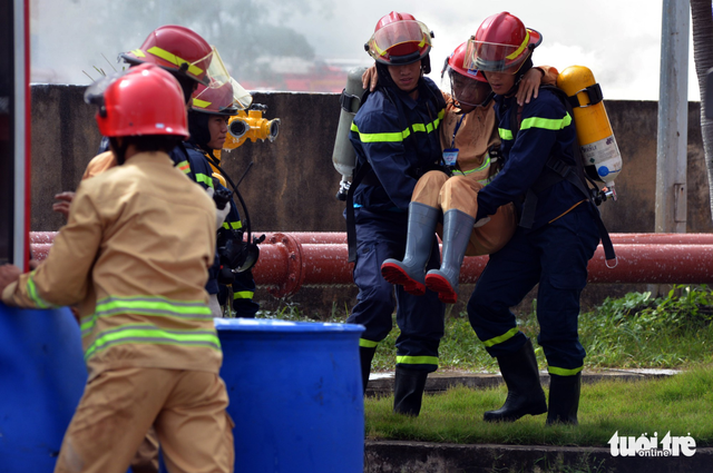 A victim of smoke inhalation is being rescued by firefighters. Photo: Tuoi Tre