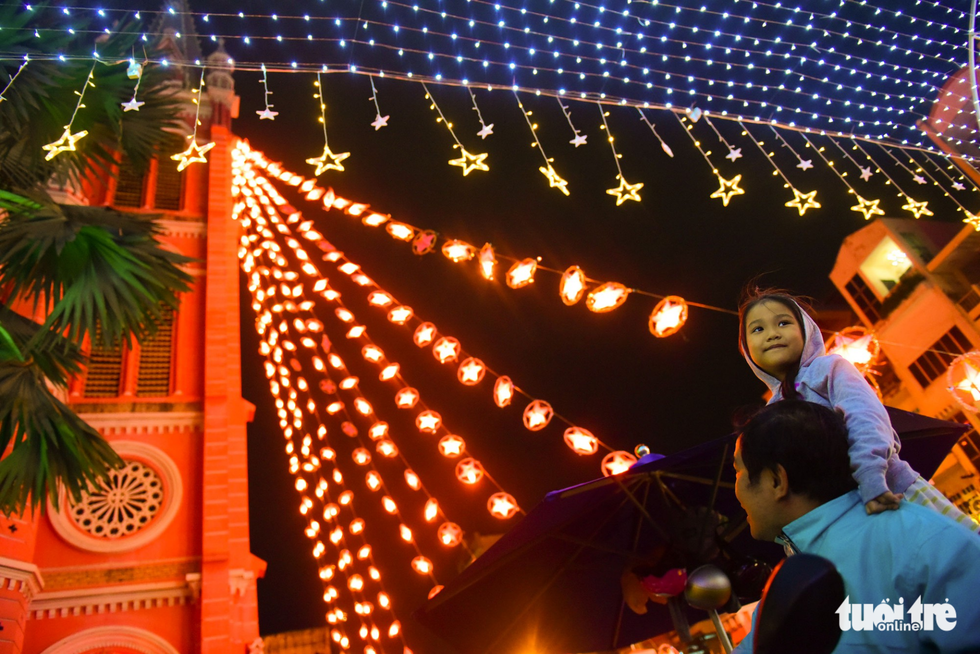 Many families take their children out to enjoy the fresh cold weather and Christmas atmosphere. Photo: Tuoi Tre