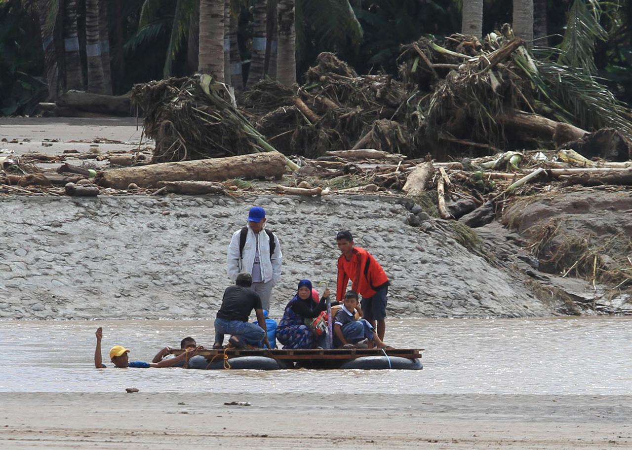 Residents are transported on a makeshift raft after a bridge was destroyed during flash floods in Salvador, Lanao del Norte in southern Philippines, December 23, 2017. Photo: Reuters