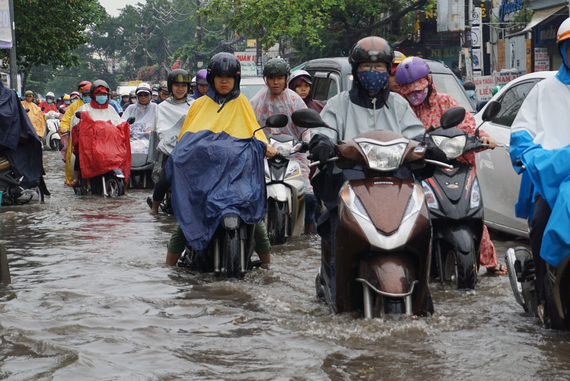 People are seen on a flooded street in Ho Chi Minh City. Photo: Tuoi Tre