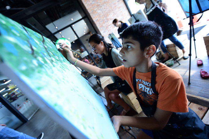 A foreign boy is intently working on his painting at a class in Ho Chi Minh City. Photo: Tuoi Tre