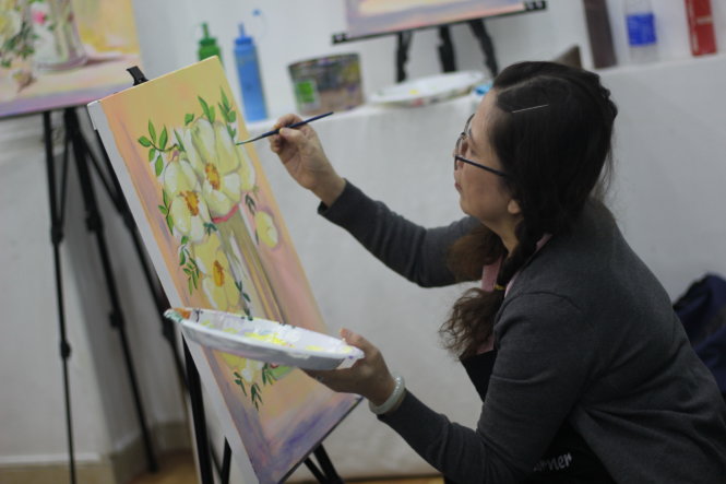 A woman gives finishing touches to her painting at a class called Paint Corner in Ho Chi Minh City. Photo: Tuoi Tre
