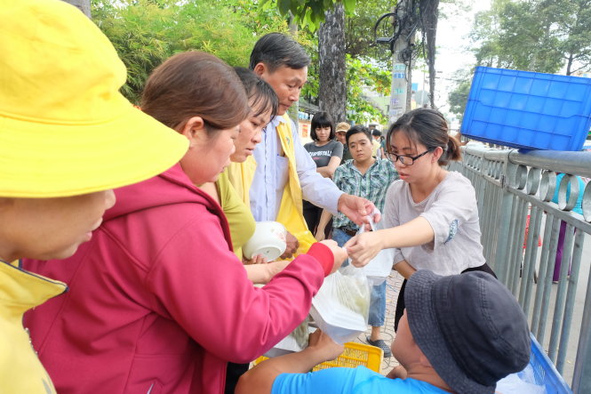 Thuy Trang (right) hands out boxes of vegan rice to patients at Cho Ray Hospital, Ho Chi Minh City. Photo: Tuoi Tre