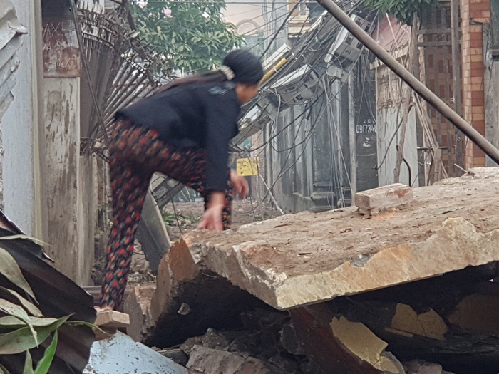 A local climbs through the rubble to get out of the danger zone. Photo: Tuoi Tre