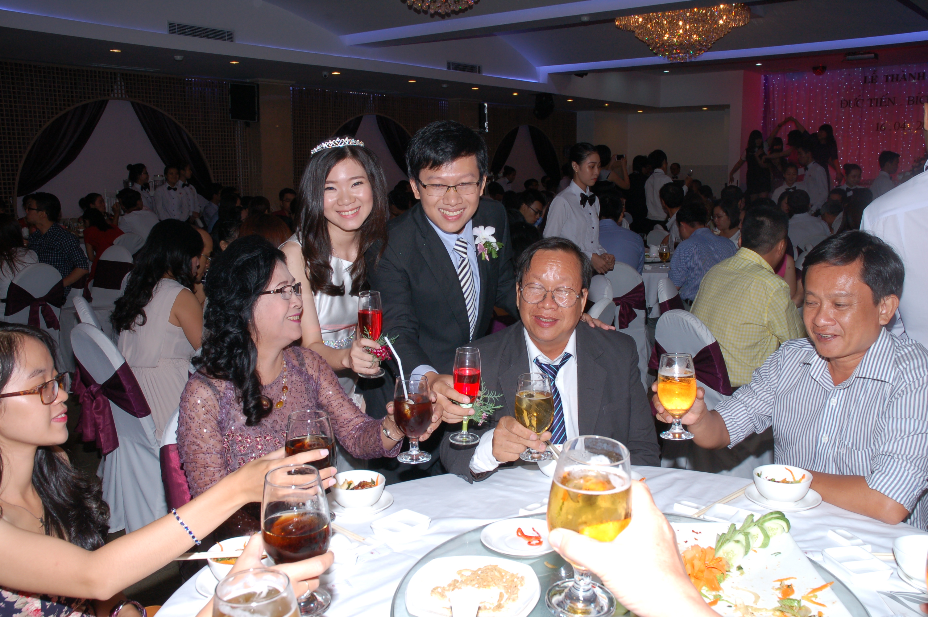 My wife and I pose and cheer at one of the twenty tables at our wedding in Ho Chi Minh City on April 16, 2015.