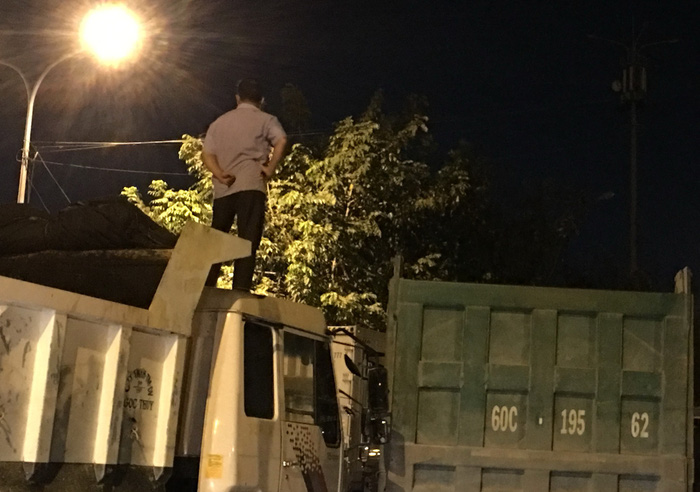 A driver stands on the roof of his truck. Photo: Tuoi Tre