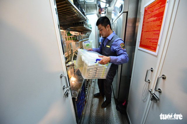 An employee carries meals onto the train.