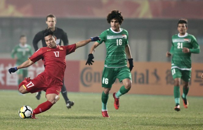 A Vietnamese player (in red) struggles to handle the ball beside an Iraqi player in their quarterfinal game at the 2018 AFC U23 Championship in China on January 20, 2018. Photo: Tuoi Tre