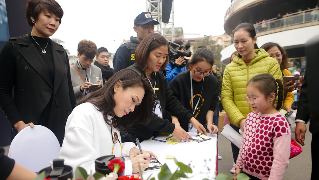 My Tam signs a copy of her album for a young fan in Hanoi. Photo: Tuoi Tre