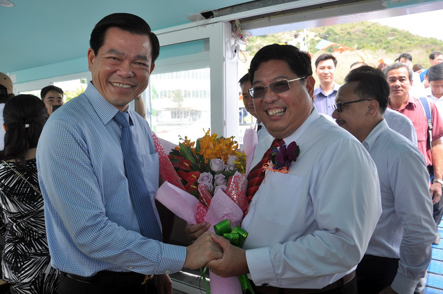 Nguyen Hong Linh (L), secretary of the Party Committee of Ba Ria-Vung Tau Province, gives flowers to Tran Song Hai, general director of Greenlines DP, as the first express boat safely docks at Vung Tau on January 28, 2018. Photo: Tuoi Tre