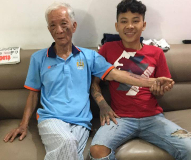 Tattoo artist Bui Van Quan (R) and his 72-year-old customer. Courtesy of Quan