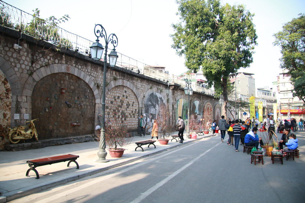 Visitors stroll along Phung Hung Street to enjoy its frescos. Photo: Tuoi Tre