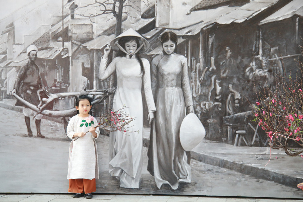 A black-and-white fresco of Vietnamese women in ao dai, the country’s traditional national outfit. Photo: Tuoi Tre