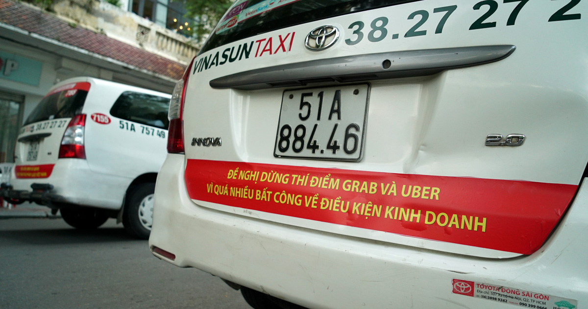 Two Vinasun taxis bearing bumper stickers denouncing Grab and Uber in this photo taken on October 8, 2017. Photo: Tuoi Tre