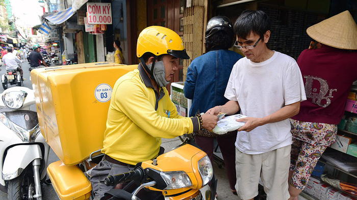 An employee of the Ho Chi Minh City Central Post Office delivers a package to a resident in District 4. Photo: Tuoi Tre