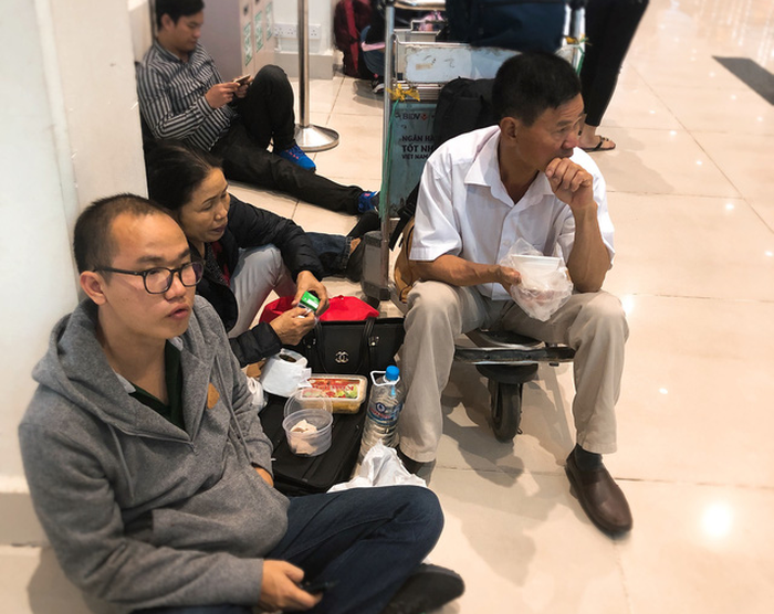Passengers have a snack during the wait. Photo: Tuoi Tre