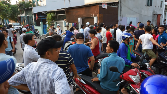 Curious on-lookers gather outside the crime scene  of a suspected mass murder at a house in Binh Tan District, Ho Chi Minh City. Photo: Tuoi Tre