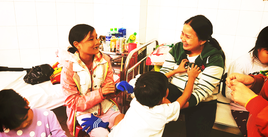 Nguyen Thi Nhu Y converses with the mother of a child at Da Nang Hospital. Photo: Tuoi Tre