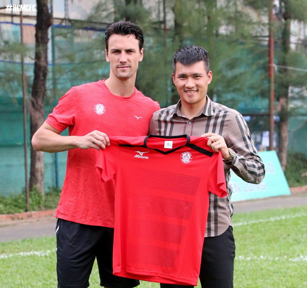 Former Manchester United midfielder Rodrigo Possebon (L) and Le Cong Ving (R), acting chairman of Ho Chi Minh City Football Club, pose for a photo with Possebon’s jersey after his recruitment in January 2018. Photo: Tuoi Tre
