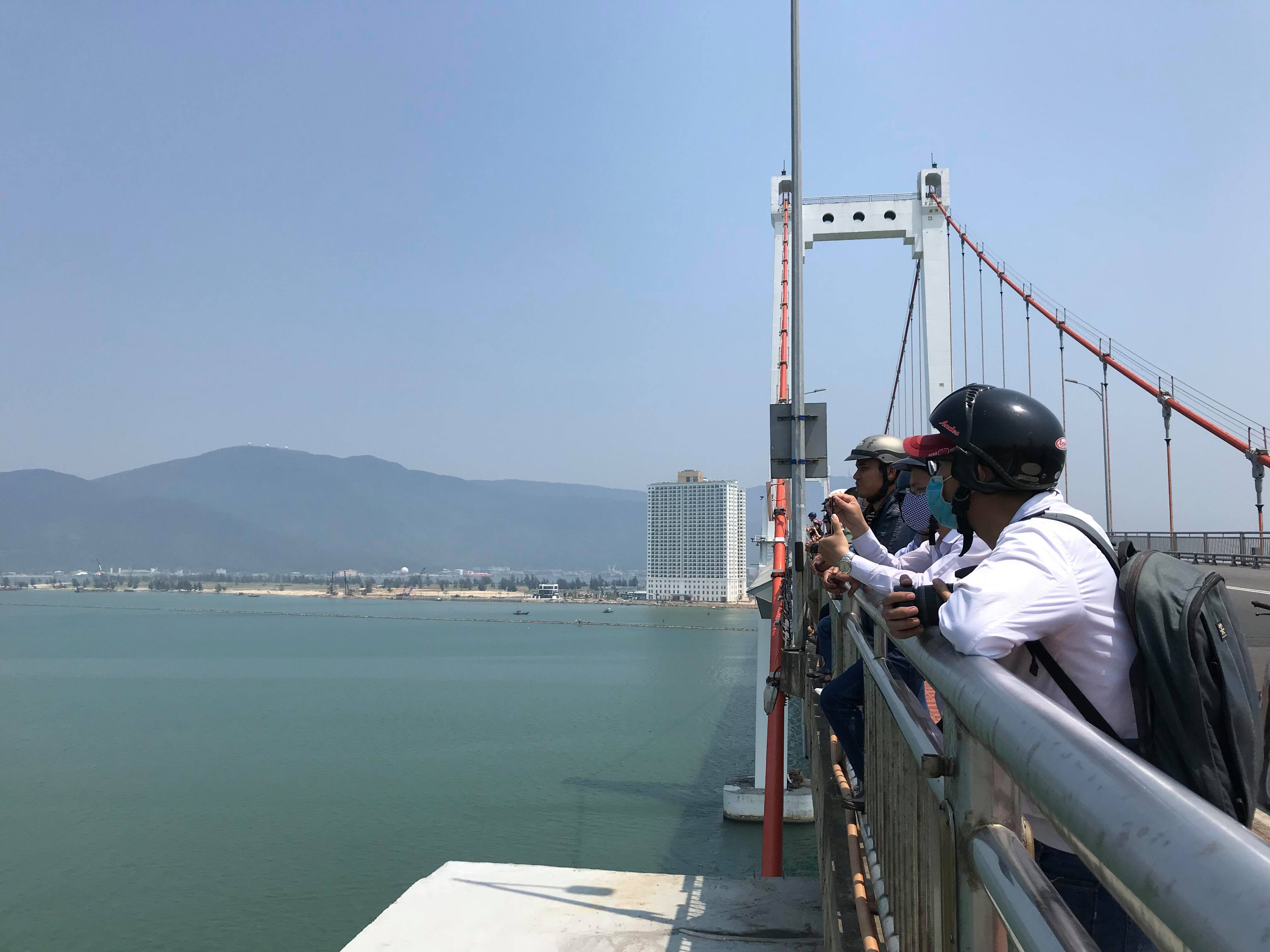 People wait on Thuan Phuoc Bridge to watch the arrival of the USS Carl Vinson in Da Nang. Photo: Tuoi Tre