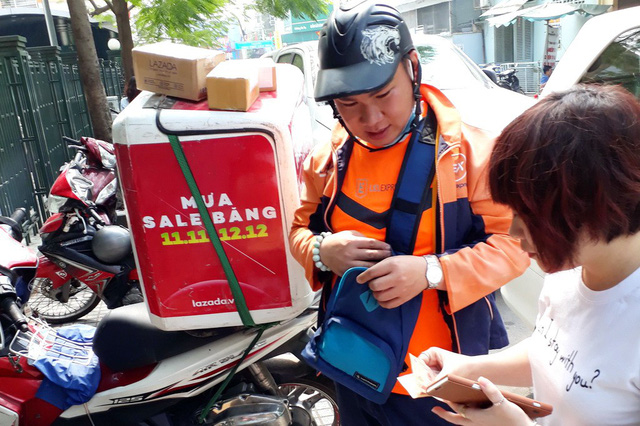 A customer receives delivery for a product she bought online in Ho Chi Minh City. Photo: Tuoi Tre