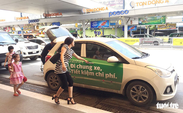 A woman enters a Grab car at Tan Son Nhat International Airport in Ho Chi Minh City. Photo: Tuoi Tre