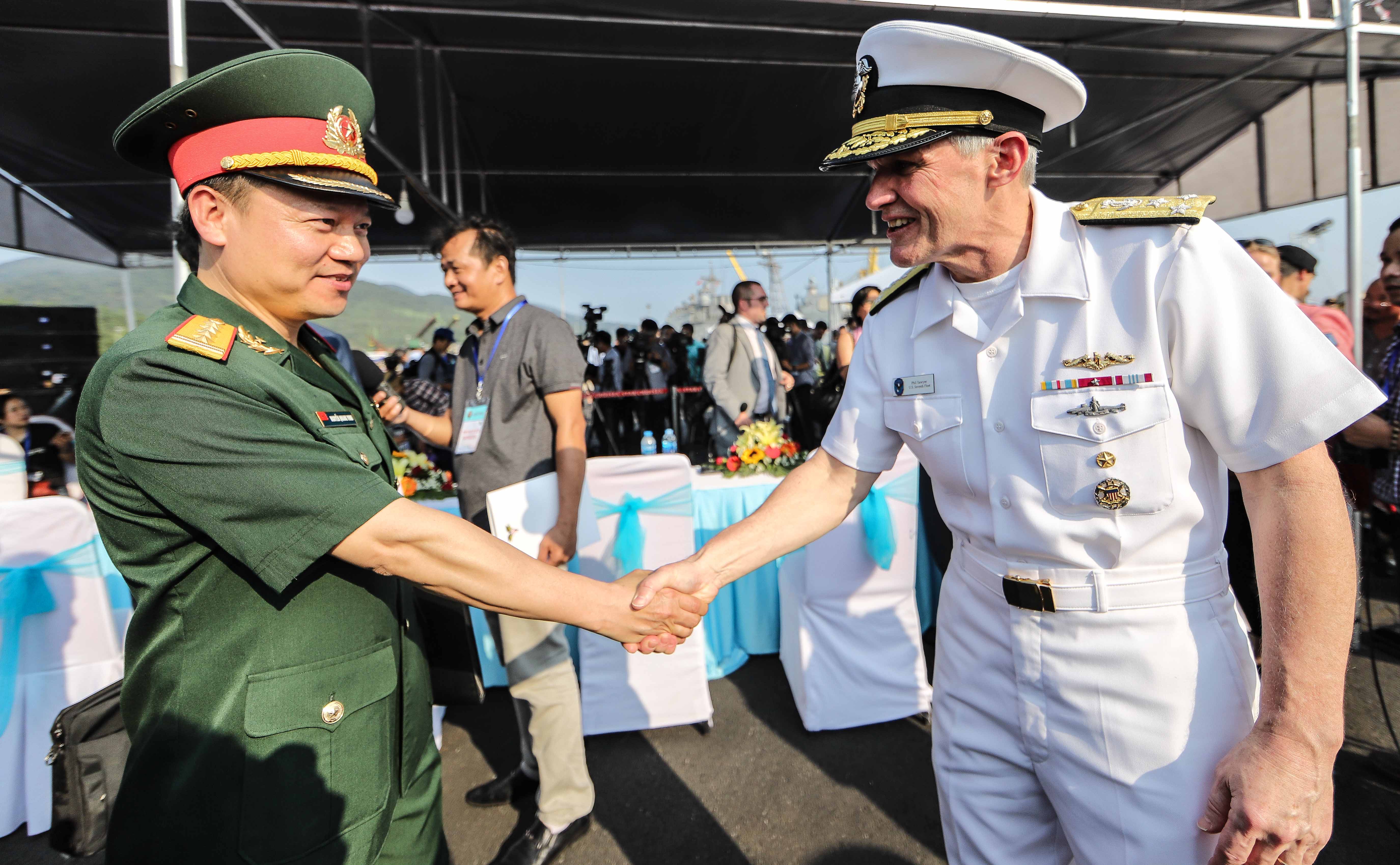 Colonel Nguyen Quang Vinh (left), deputy head of the Department of External Affairs, Ministry of Denfense, shakes hands with Vice Admiral Phillip Sawyer, Commander of the 7th fleet, US Navy, during a welcome ceremony at the Tien Sa Port, Da Nang, on March 5, 2018. Photo: Nguyen Khanh / Tuoi Tre