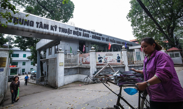 A woman pushes her bicycle past one of the properties of AVG in Hanoi. Photo: Tuoi Tre