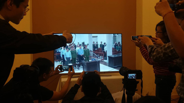 Local reporters witness the trial via a TV screen at the court. Photo: Tuoi Tre