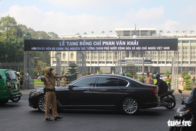 A traffic police officer controls traffic in front of the Reunification Palace.