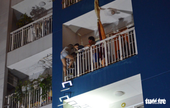 People climb out of the building. Photo: Tuoi Tre